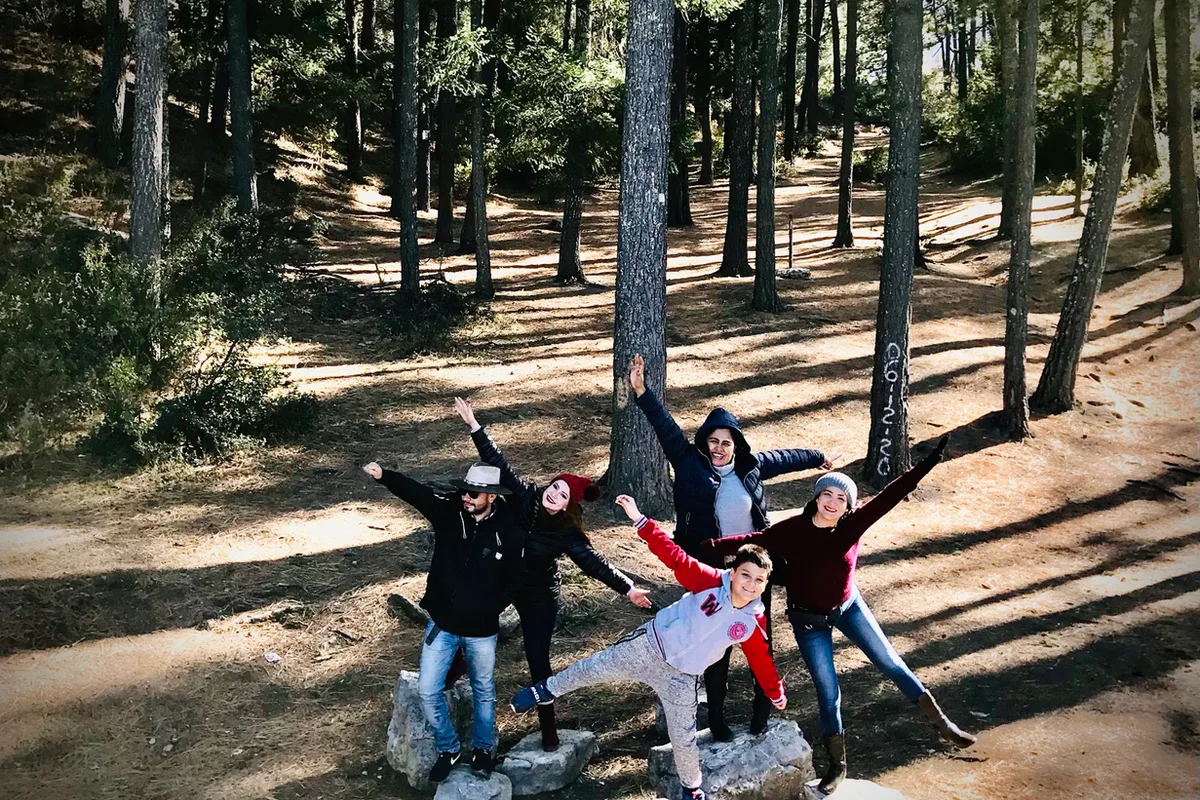Tres amigas ríen entre los pinos nevados de Arteaga durante una escapada de invierno