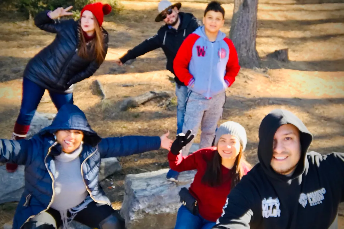 Grupo de amigos celebra con los brazos en alto en el bosque de pinos de Arteaga