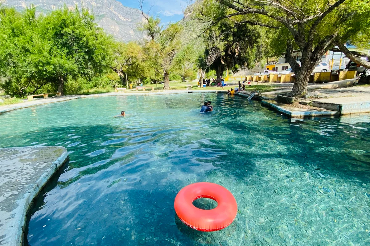 Río de aguas cristalinas rodeado de árboles frondosos en el pueblo mágico de Bustamante