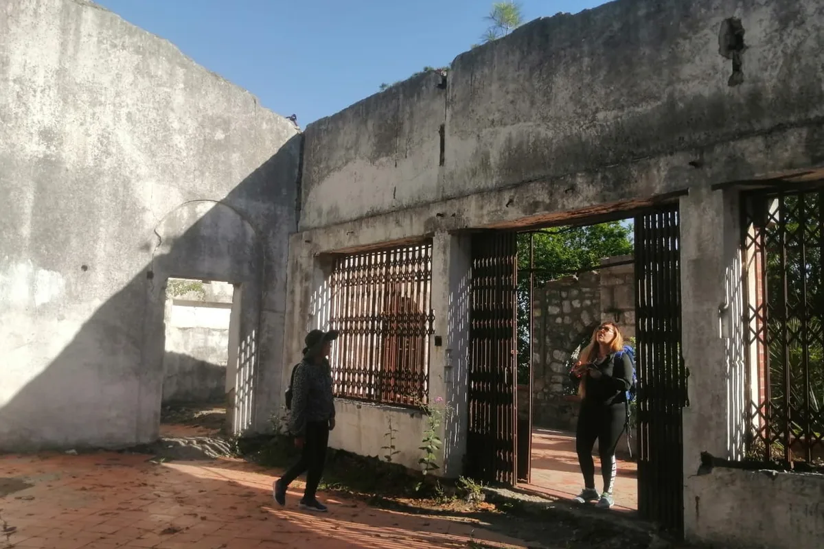 Excursionistas recorren las ruinas de piedra de la antigua capilla dentro de Chipinque