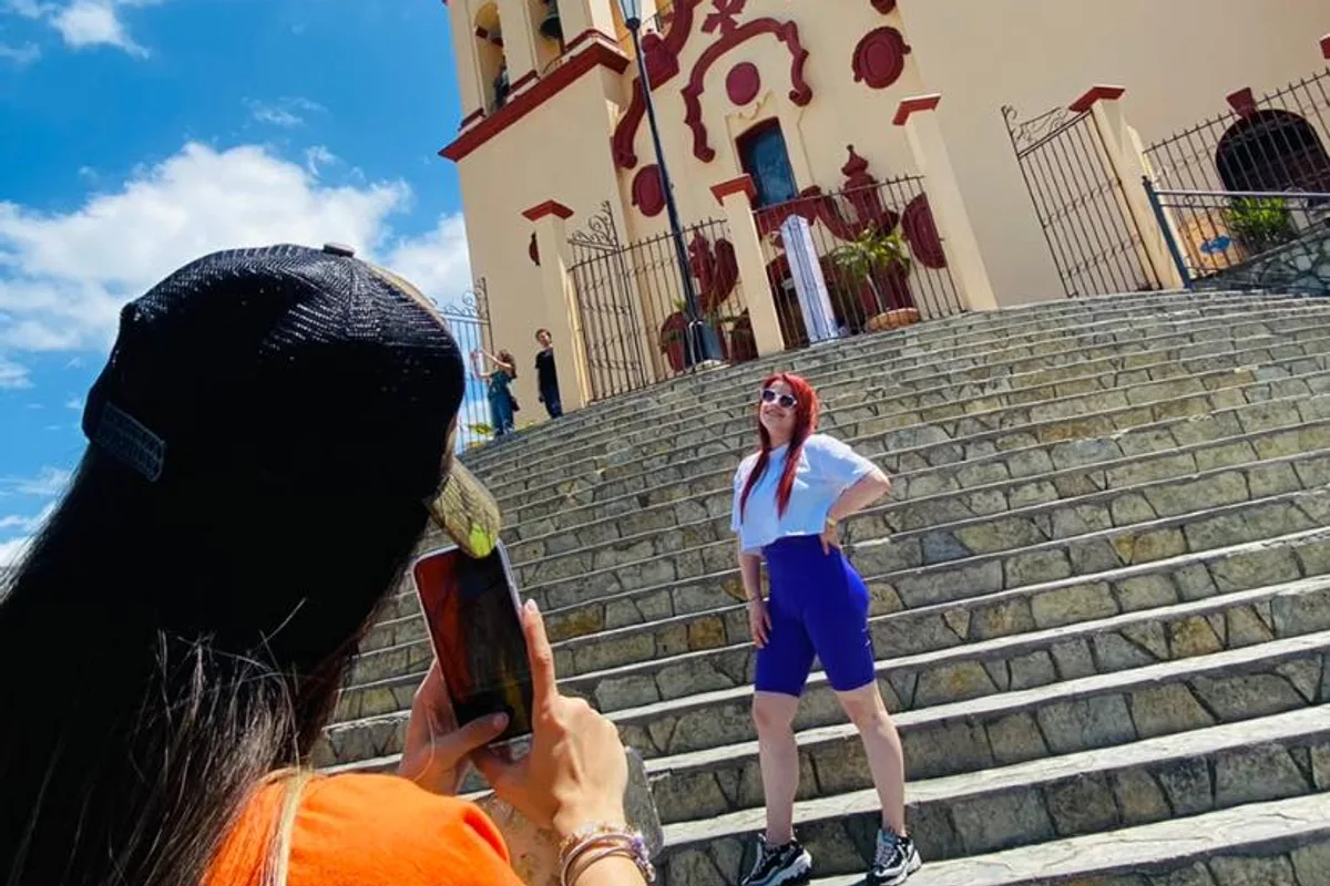 Turista se fotografía en las escalinatas de la parroquia de Santiago, Nuevo León, Pueblo Mágico