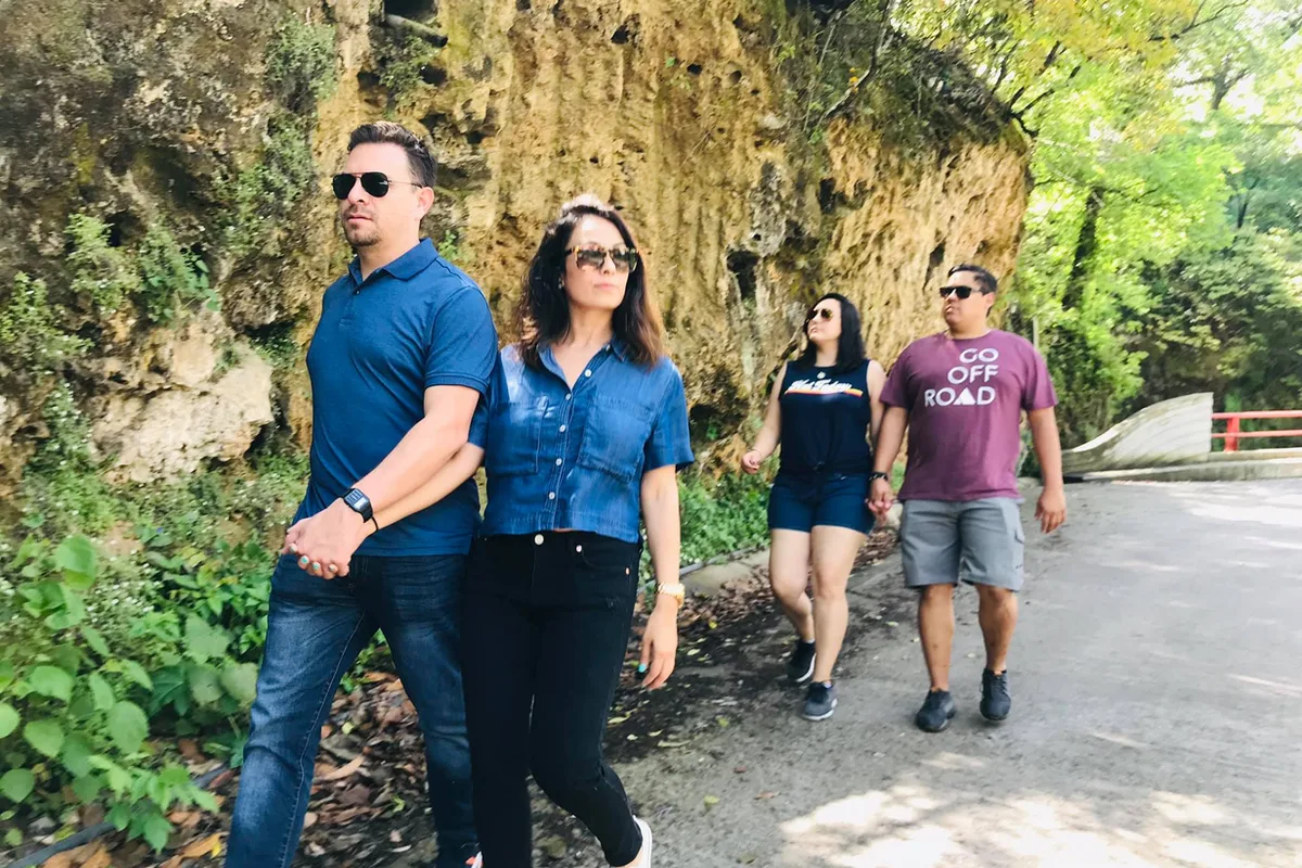 Grupo de visitantes camina por el sendero de piedra rumbo a la cascada Cola de Caballo en Santiago