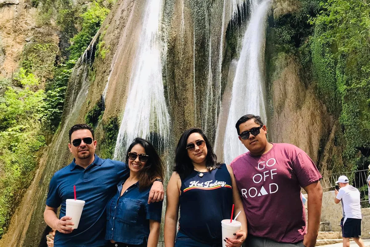 Grupo de amigos disfruta bebidas frías frente a las caídas de agua de Cola de Caballo