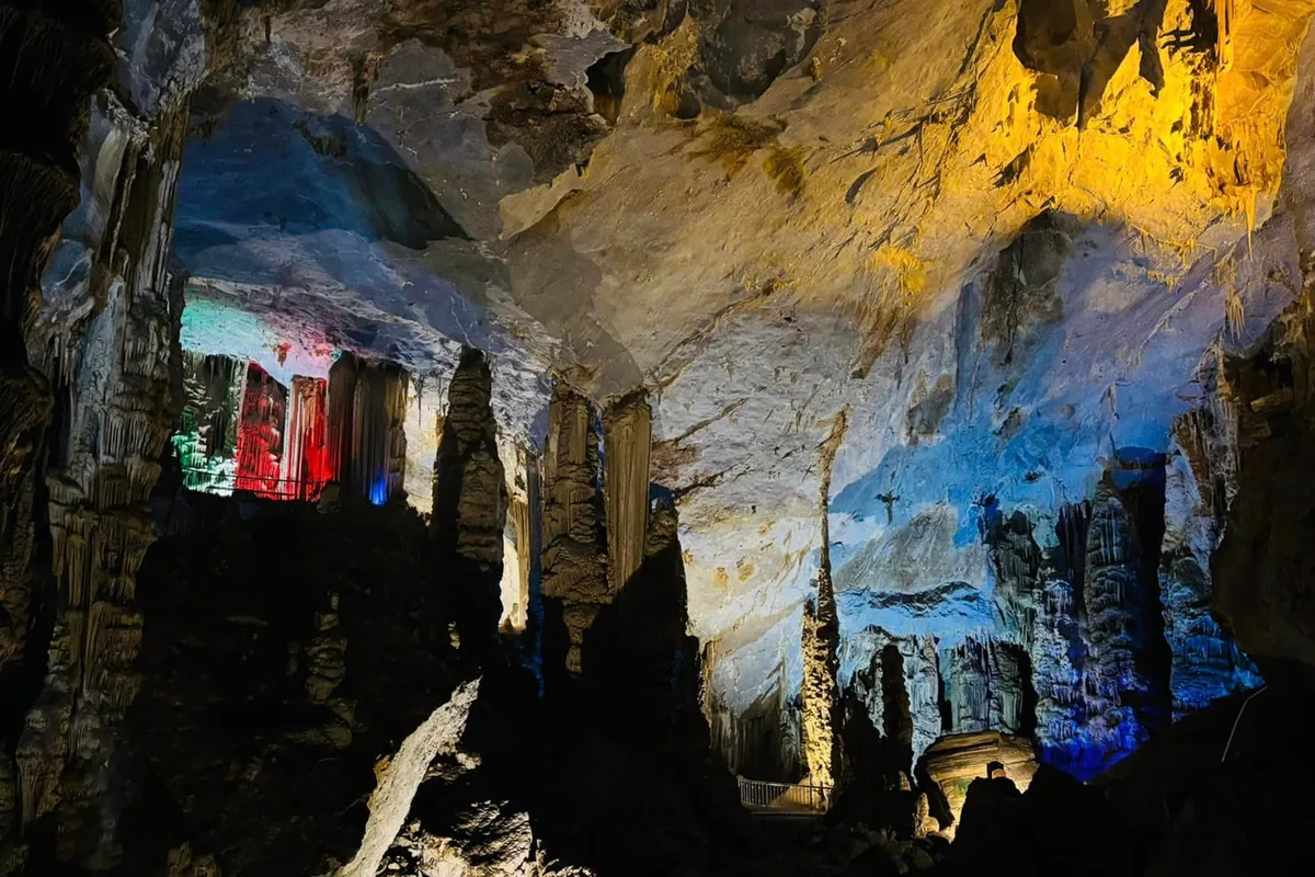 Formaciones de estalactitas iluminadas en rojo y azul dentro de las Grutas de García