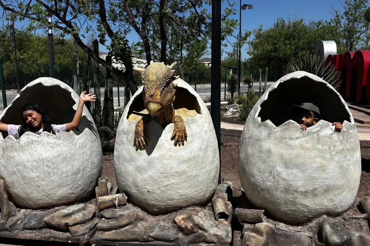 Réplicas de pterodáctilos cuelgan entre los árboles del recorrido en Dinolandia