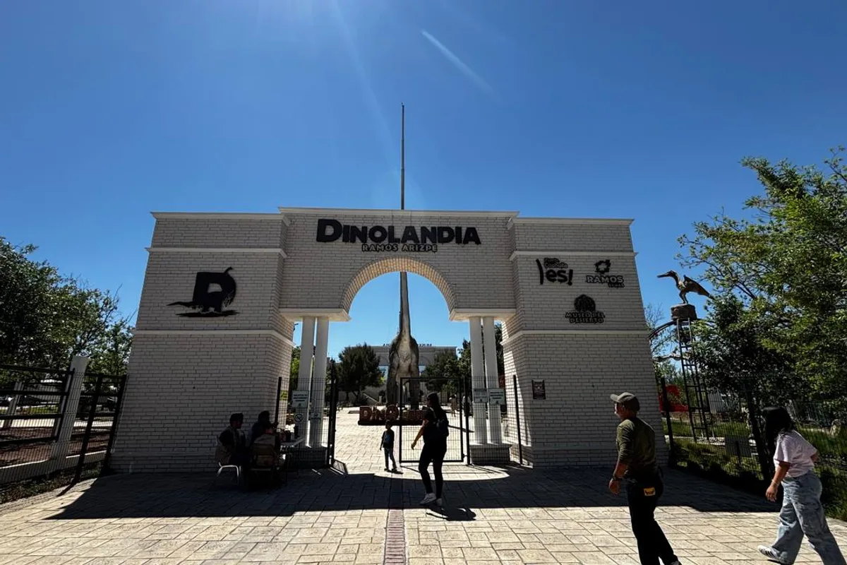 Familia se fotografía junto a una escultura gigante de dinosaurio de cuello largo