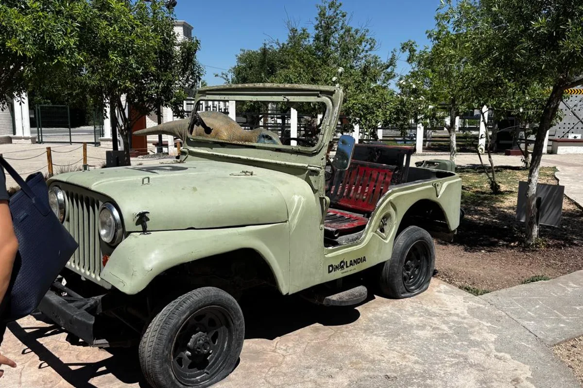 Jeep vintage con decoración temática de dinosaurios en las instalaciones de Dinolandia