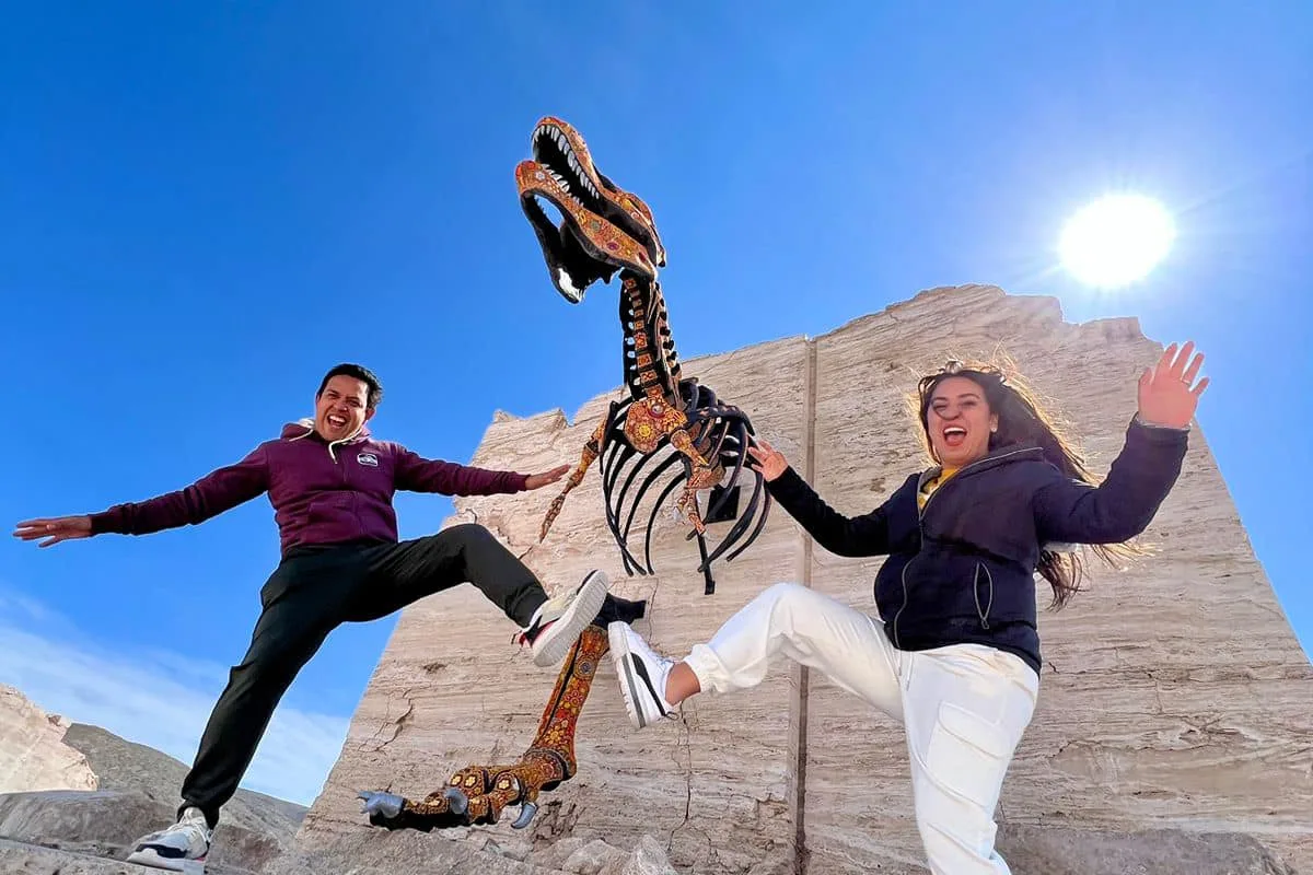 Pareja posando junto a un esqueleto de dinosaurio en las Dunas de Yeso de Coahuila