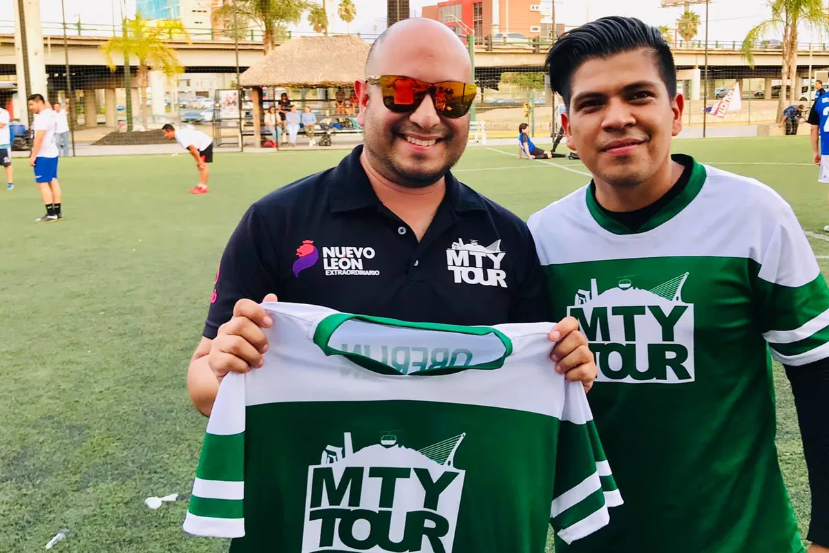 Colaboradores de Monterrey Tour sosteniendo el jersey del equipo tras un partido de fútbol