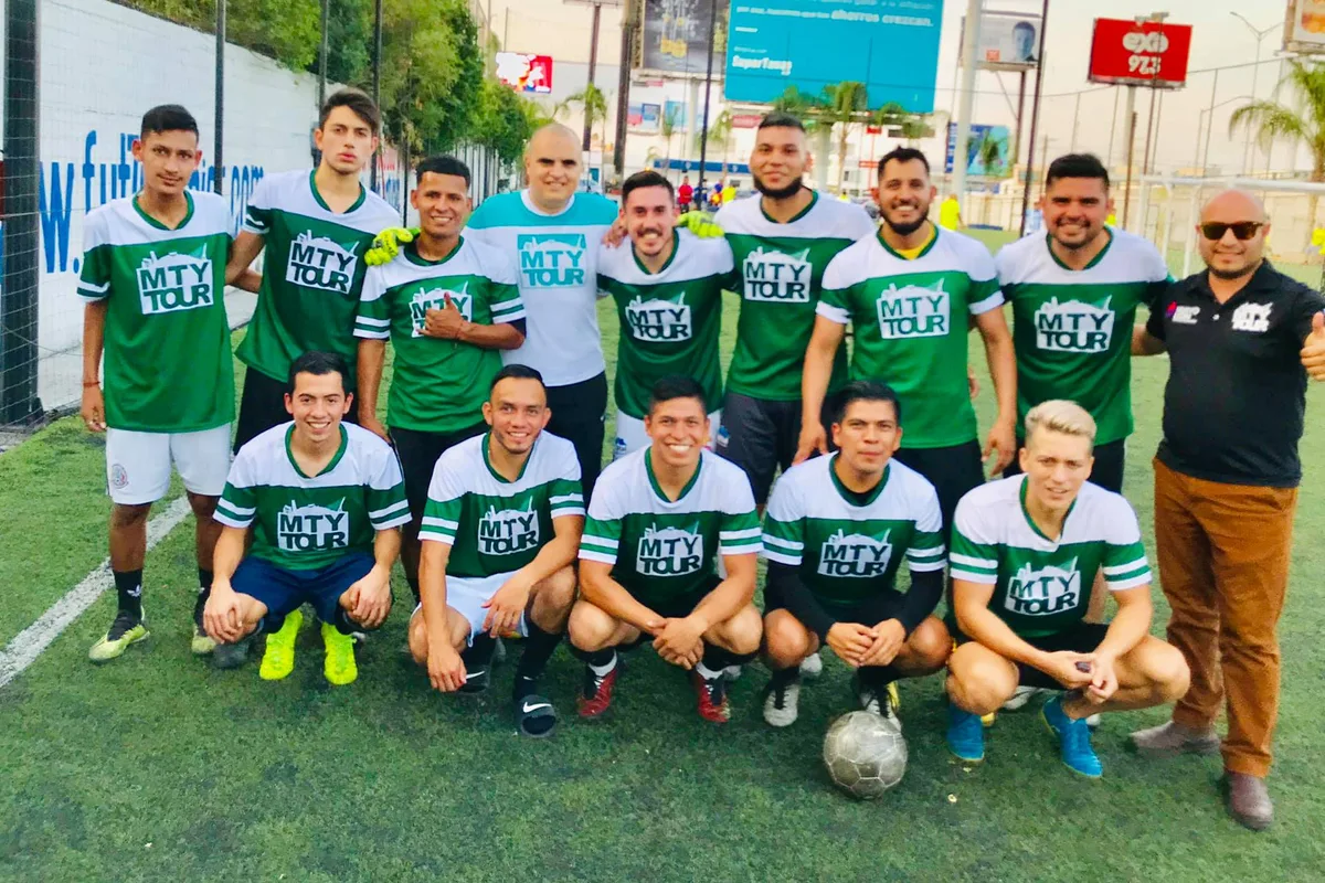 Equipo completo de fútbol de Monterrey Tour posando en la cancha durante evento de integración