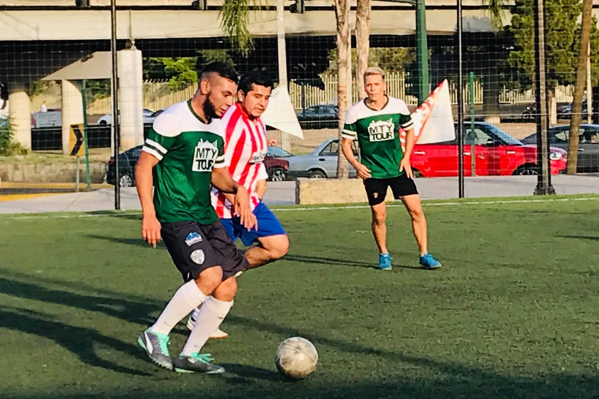 Jugadores del equipo Monterrey Tour disputando el balón durante un partido amistoso de fútbol
