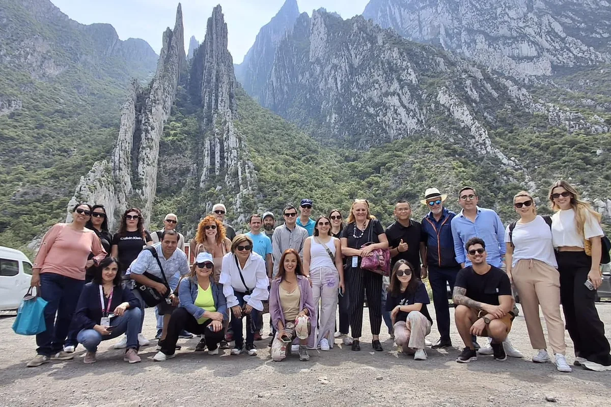 Grupo de turistas posa frente a los picos rocosos de la Sierra Madre cerca de las Grutas de García