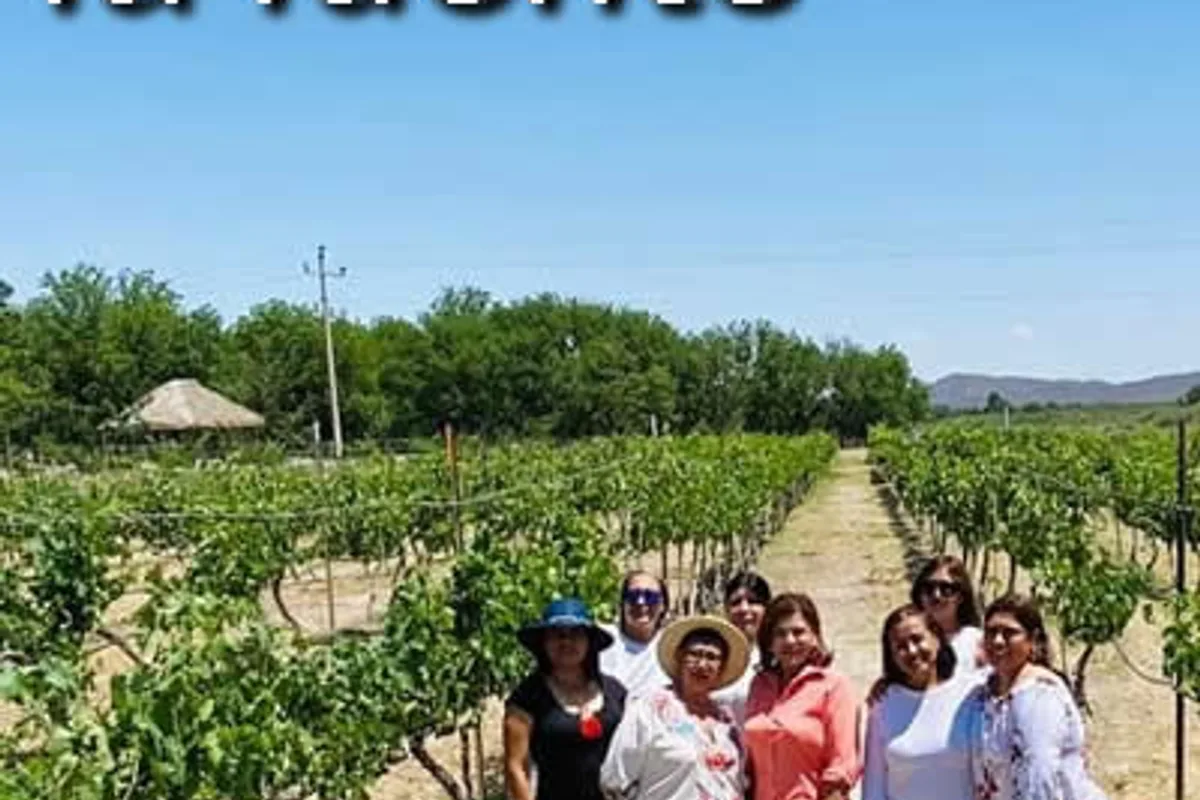 Grupo de siete mujeres sonríe entre los viñedos de un rancho en la región de Parras.