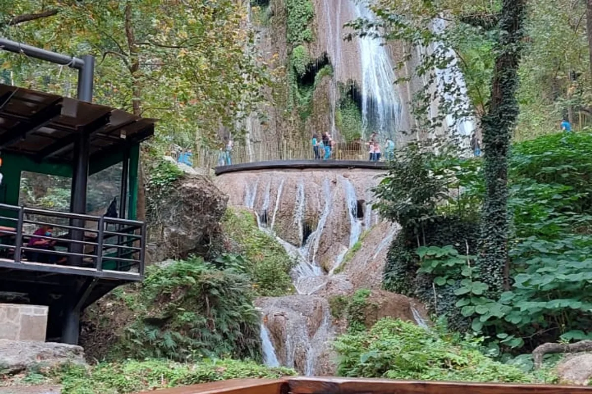Vista panorámica de la cascada Cola de Caballo con mirador de madera entre la vegetación