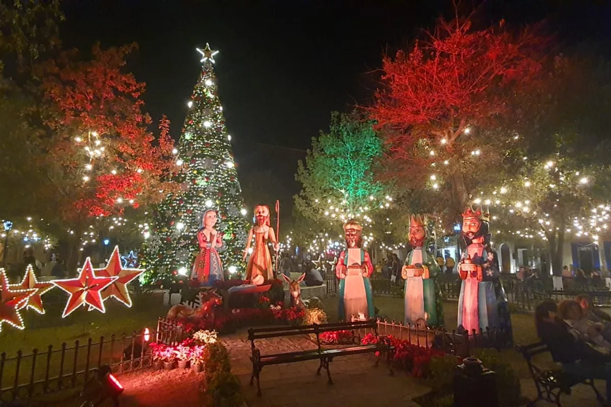 Plaza principal del pueblo mágico iluminada con árbol de Navidad gigante y figuras de los Reyes Magos