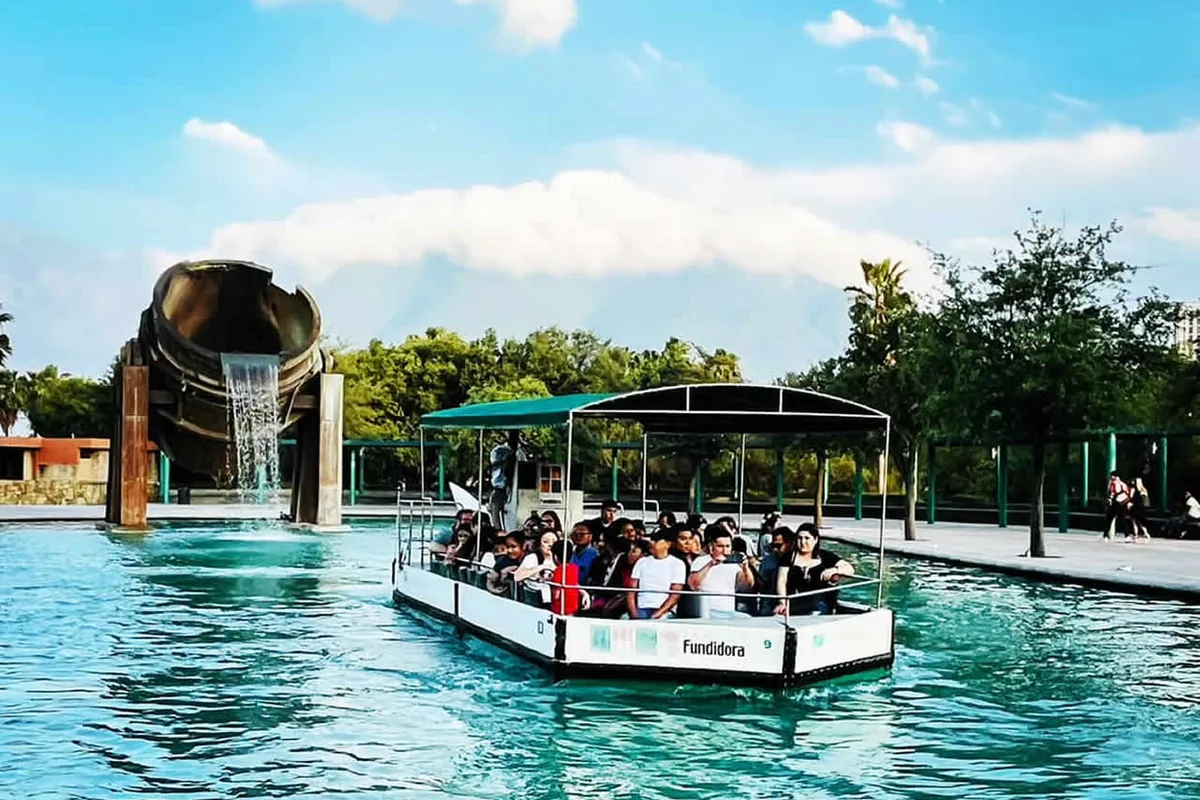 Turistas navegan en lancha frente a la fuente de la Nave Mayor en el Parque Fundidora