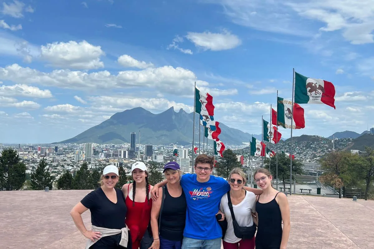 Grupo con banderas mexicanas en el mirador del Cerro de la Silla con vista panorámica de Monterrey