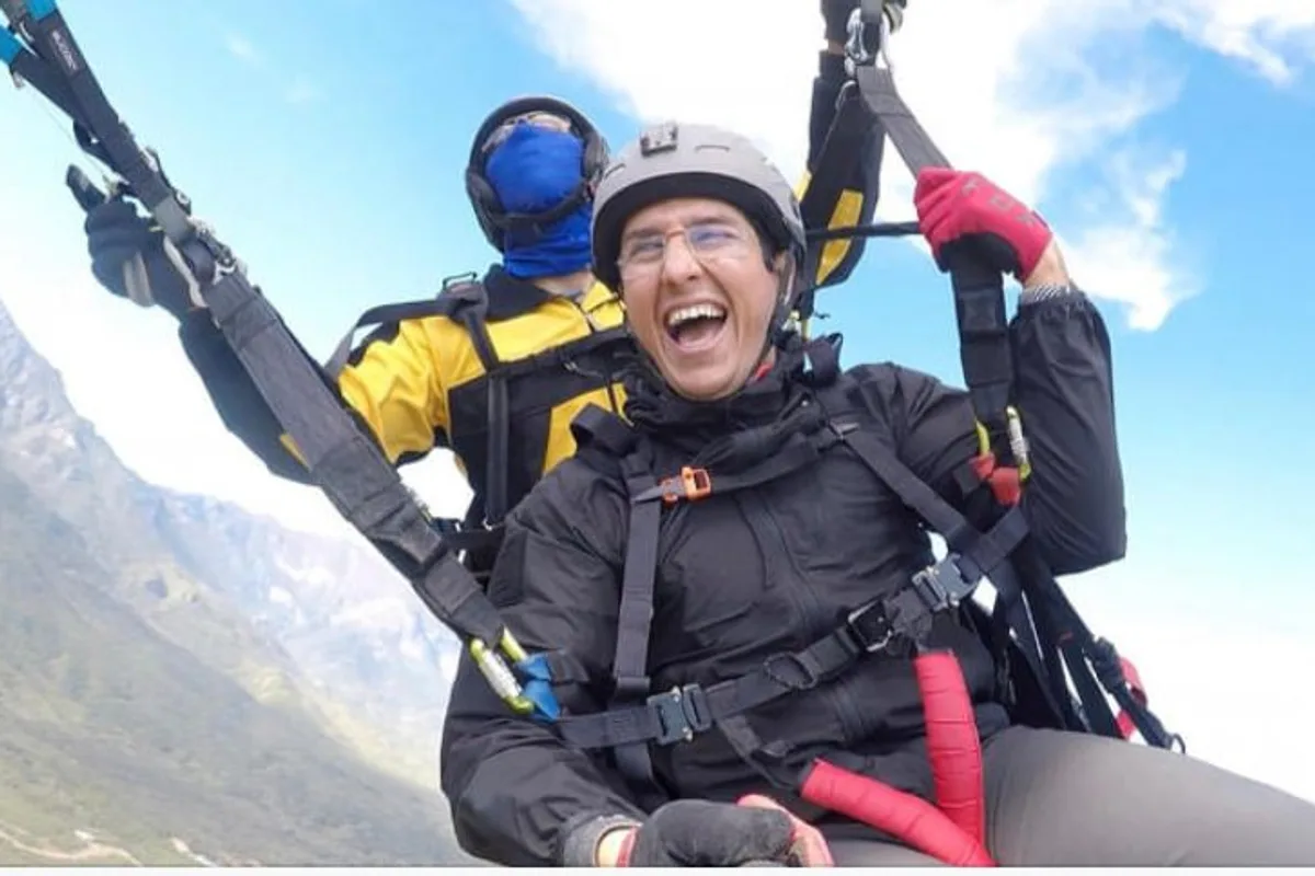Mujer sonríe emocionada durante un vuelo en parapente biplaza sobre Monterrey
