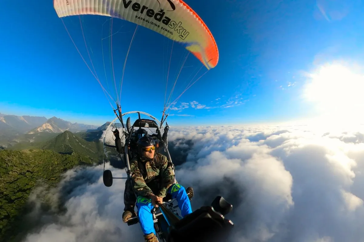 Piloto de paratrike sobrevuela un mar de nubes al amanecer en Monterrey