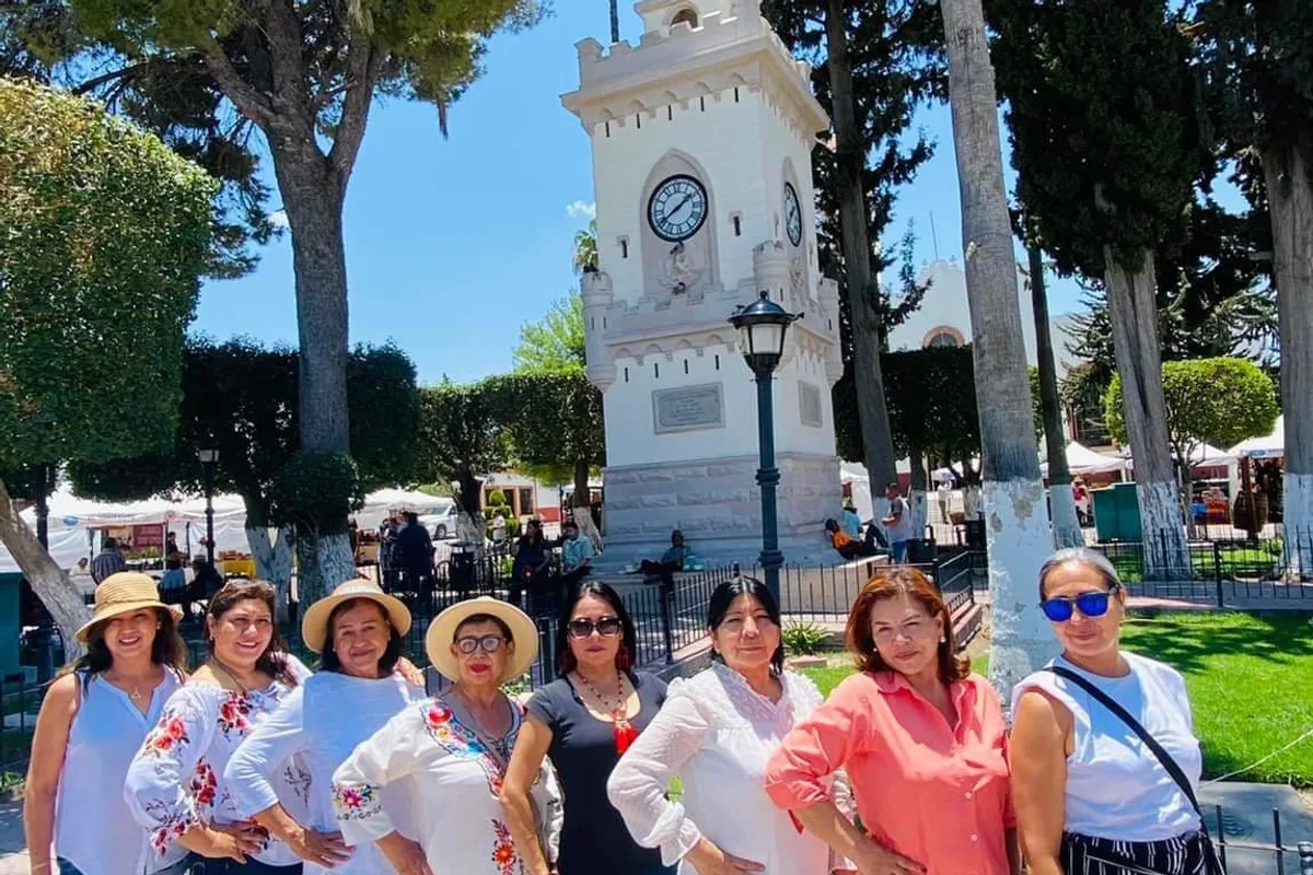 Turistas frente a la torre del reloj en la plaza principal de Parras de la Fuente
