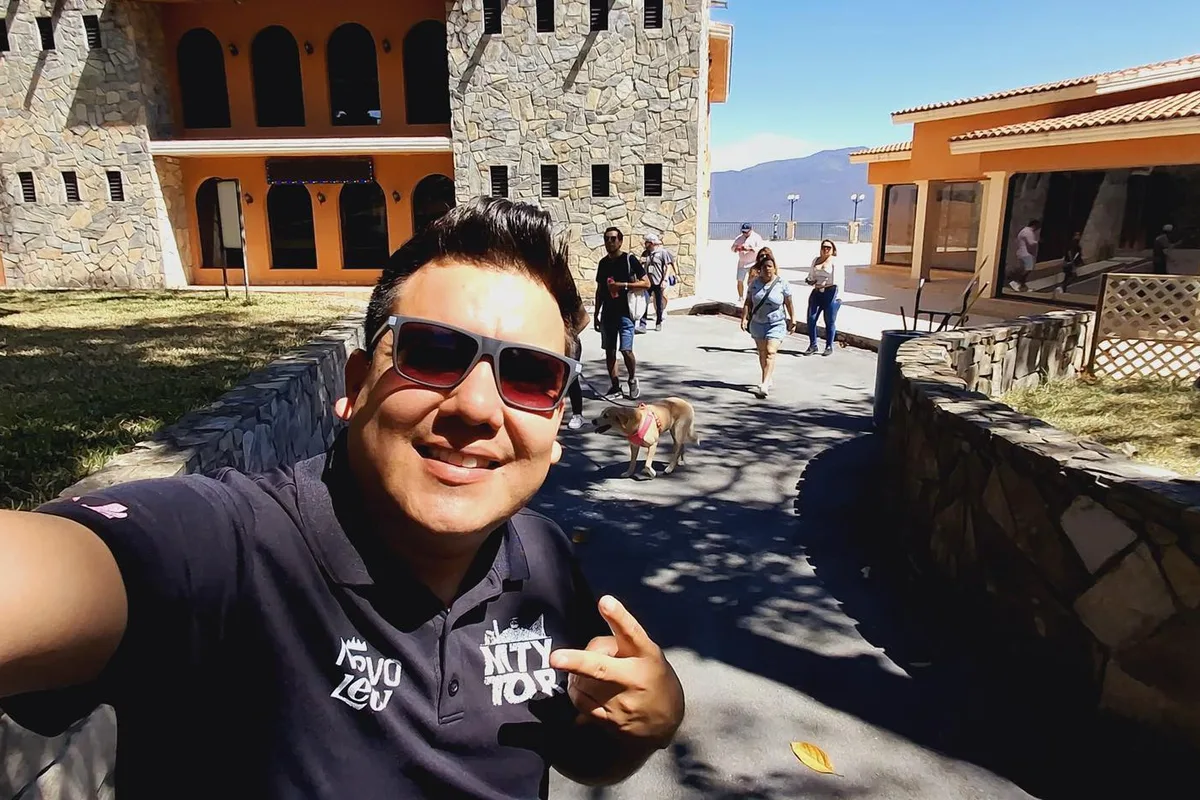 Pareja de turistas posa con su perro frente a una cascada durante un tour pet-friendly en Monterrey