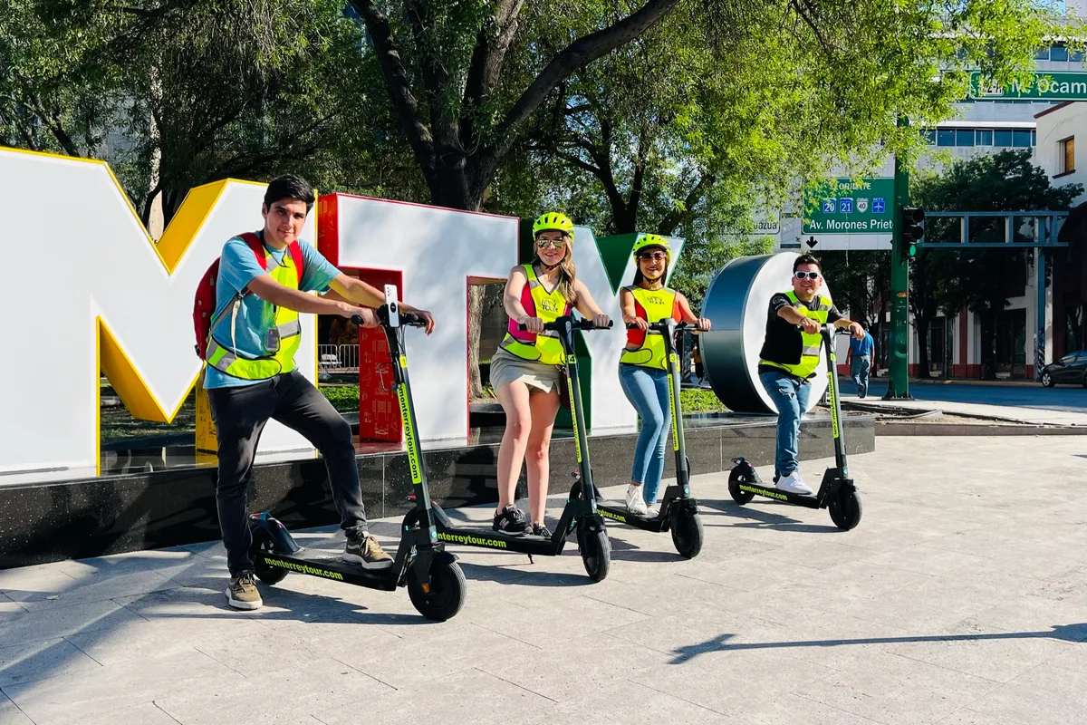 Grupo posa en patín eléctrico junto a las letras monumentales de MTY en el centro de Monterrey